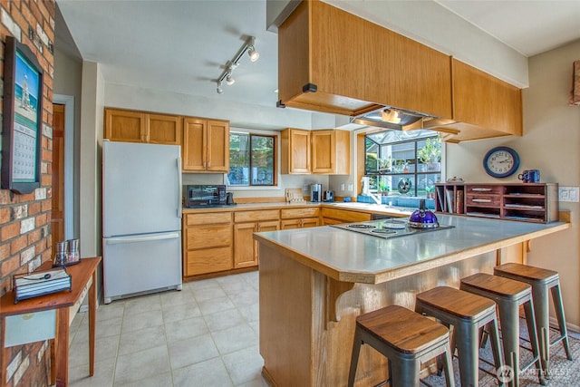 519 Highlands Dr, Orcas Island, WA 98245 - kitchen featuring freestanding refrigerator, a peninsula, cooktop, light countertops, and a breakfast bar area