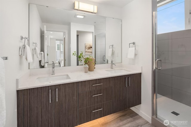 ensuite bathroom featuring a sink, double vanity, and a stall shower