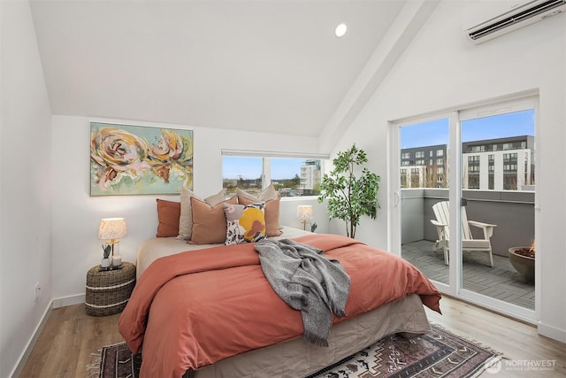 bedroom featuring wood finished floors, multiple windows, a wall mounted AC, and access to exterior