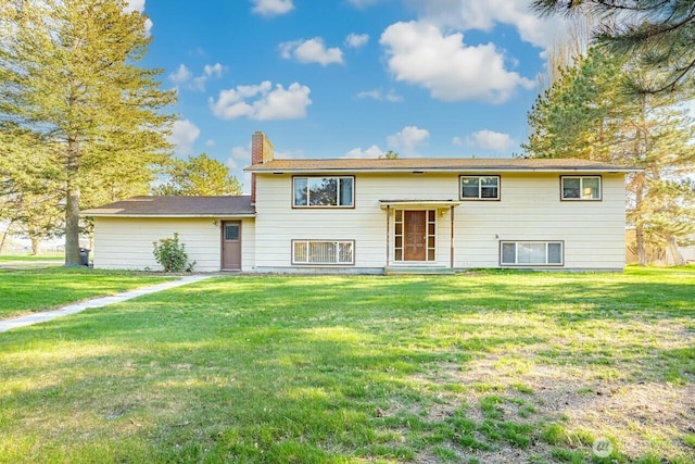 raised ranch featuring a chimney and a front yard