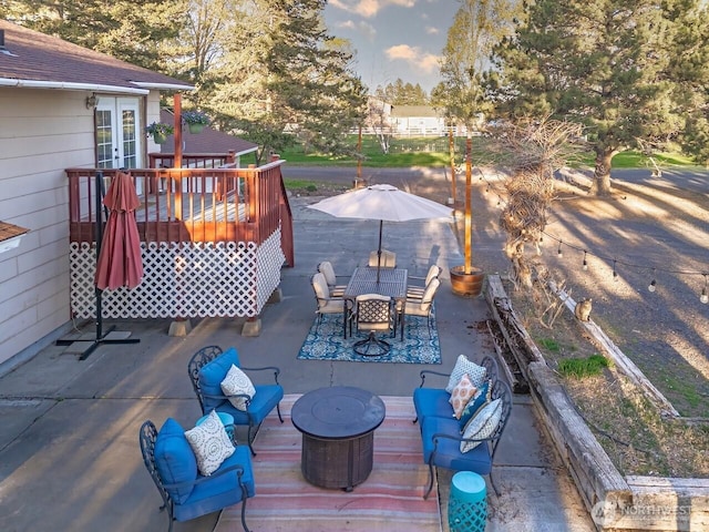 deck featuring outdoor dining area, a patio area, and french doors