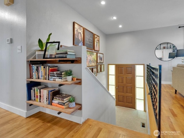 foyer featuring baseboards, wood finished floors, visible vents, and recessed lighting