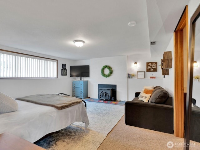 carpeted bedroom featuring a wood stove