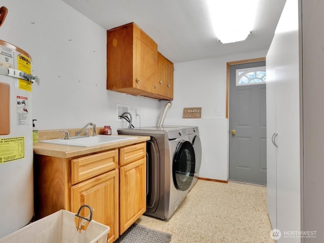 laundry room featuring a sink, washing machine and clothes dryer, baseboards, strapped water heater, and cabinet space