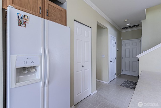14231 SE 282nd St, Kent, WA 98042 - kitchen with brown cabinetry, white fridge with ice dispenser, light countertops, ornamental molding, and visible vents
