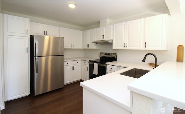 kitchen featuring stainless steel appliances, a sink, a peninsula, white cabinets, and recessed lighting