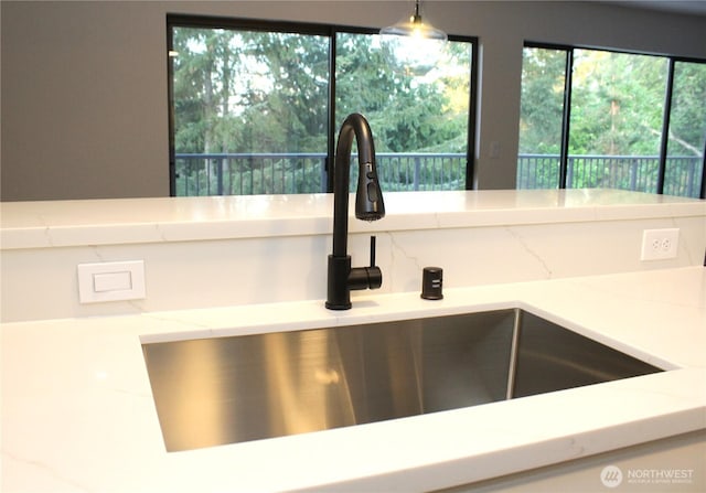 kitchen view of a sink and light stone counters