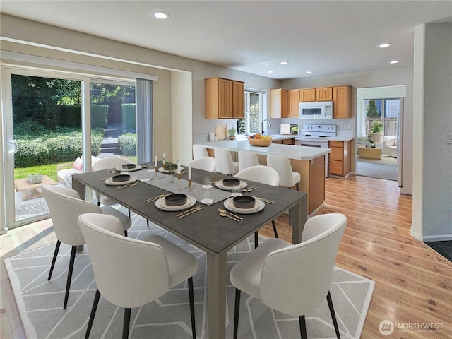 dining room featuring light wood-type flooring, recessed lighting, and a wealth of natural light
