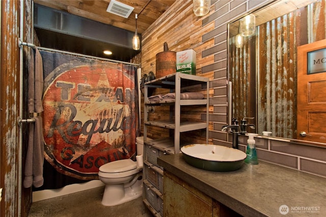 25012 67th Ave E, Graham, WA 98338 - bathroom featuring wood walls, visible vents, toilet, vanity, and a shower with shower curtain