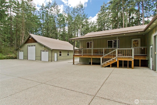 25012 67th Ave E, Graham, WA 98338 - rear view of property featuring a detached garage, board and batten siding, covered porch, an outbuilding, and roof with shingles