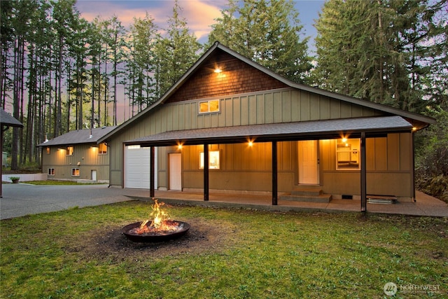 25012 67th Ave E, Graham, WA 98338 - back of house with a yard, driveway, a shingled roof, and an outdoor fire pit