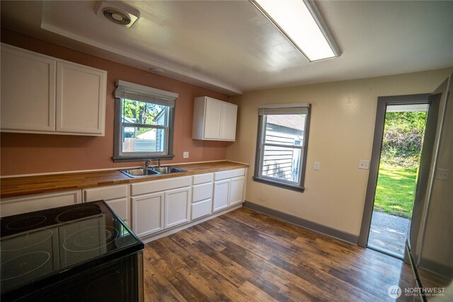 914 Puget St NE, Olympia, WA 98506 - kitchen with a sink, black range with electric cooktop, dark wood-style floors, and white cabinetry