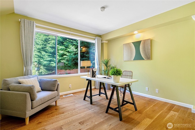 home office with visible vents, baseboards, lofted ceiling, and wood finished floors