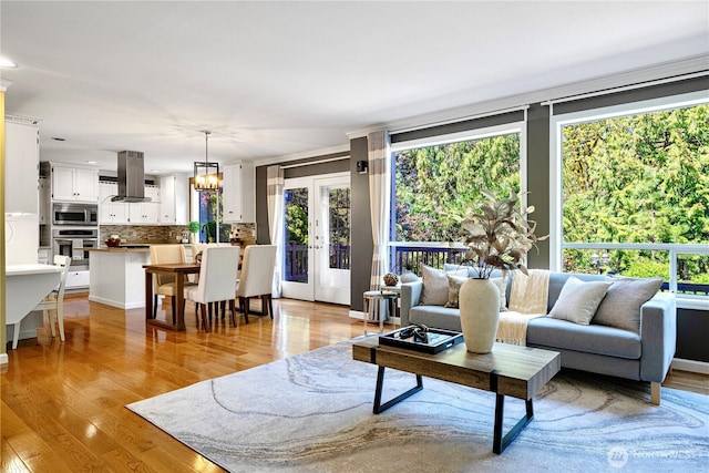 living area with light wood-type flooring and a notable chandelier