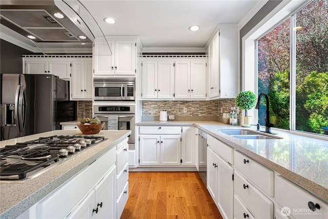 kitchen with a sink, crown molding, stainless steel appliances, and tasteful backsplash