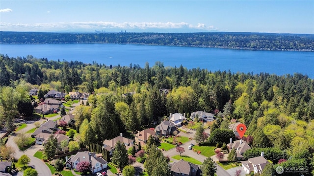 aerial view featuring a residential view, a water view, and a wooded view