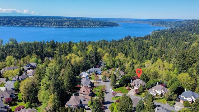 aerial view with a water view, a view of trees, and a residential view