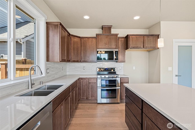 9621 7th Ave SE, Lacey, WA 98513 - kitchen with stainless steel appliances, light wood finished floors, backsplash, light countertops, and recessed lighting