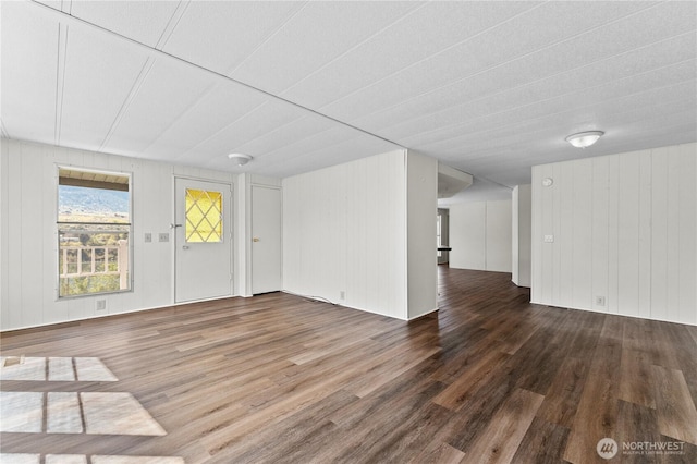 unfurnished living room featuring wood walls and wood finished floors
