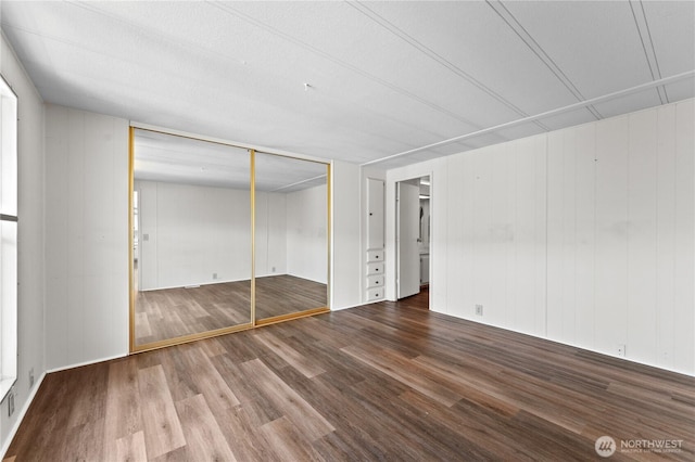 unfurnished bedroom with wood finished floors and a closet