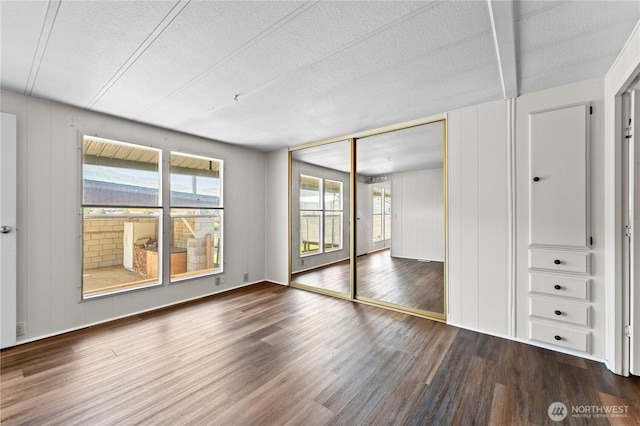 unfurnished bedroom with wood finished floors, a textured ceiling, and a closet