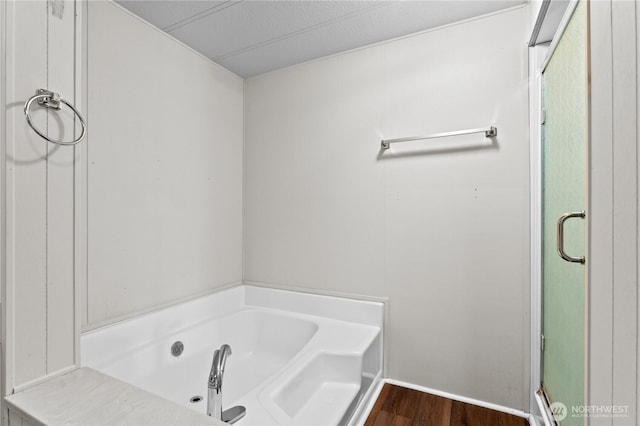 bathroom featuring a bath and wood finished floors