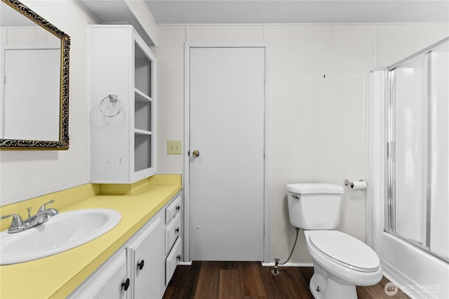 full bathroom featuring toilet, walk in shower, vanity, and wood finished floors