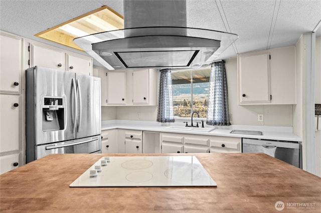 kitchen with appliances with stainless steel finishes, a sink, white cabinetry, and light countertops