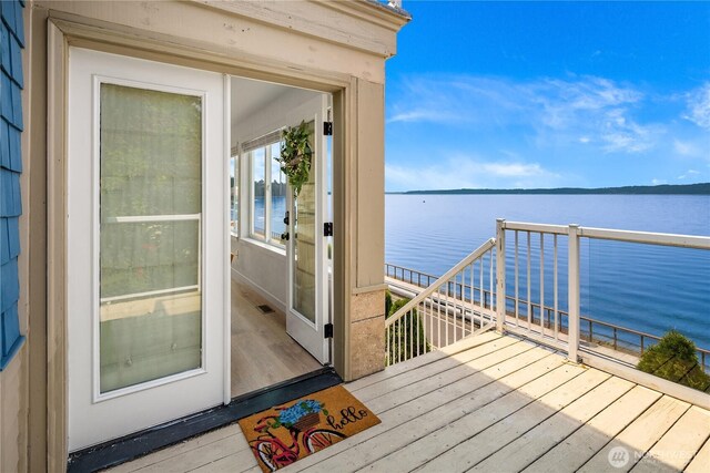 wooden deck featuring a water view and visible vents