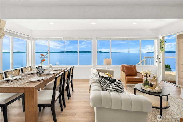sunroom featuring a water view