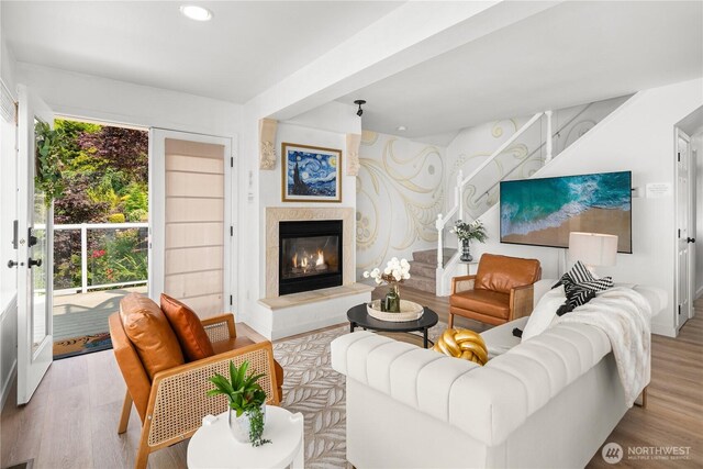 living area featuring recessed lighting, a glass covered fireplace, and wood finished floors