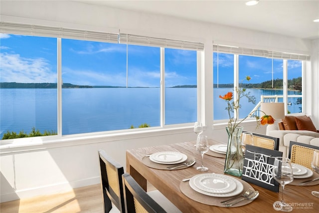 sunroom featuring a water view