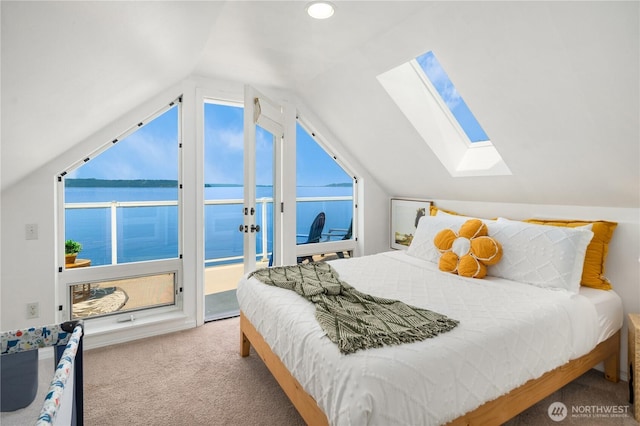 carpeted bedroom featuring access to outside, vaulted ceiling with skylight, and multiple windows