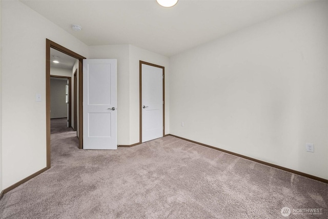 unfurnished bedroom featuring carpet floors and baseboards