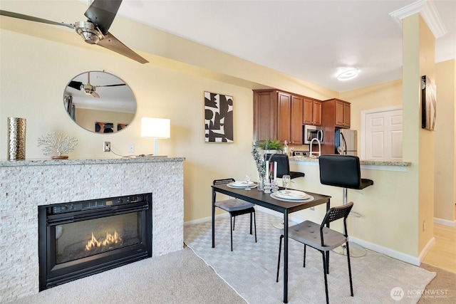 225 Logan Ave S Unit 205, Renton, WA 98057 - dining space with light carpet, baseboards, and a glass covered fireplace