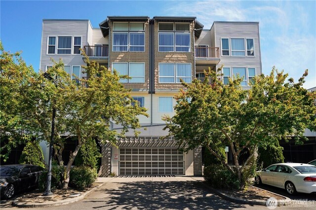 225 Logan Ave S Unit 205, Renton, WA 98057 - view of building exterior featuring a garage and driveway