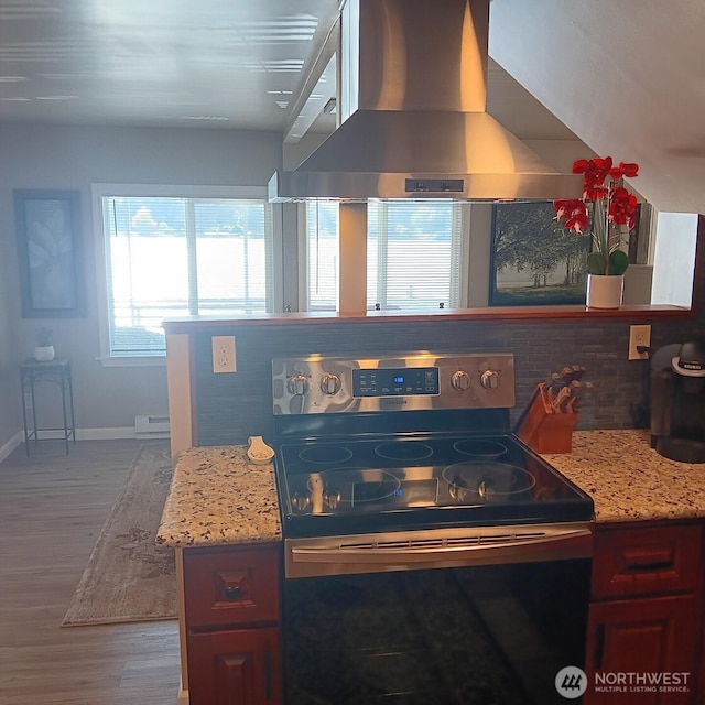 kitchen featuring light stone countertops, stainless steel electric range, wood finished floors, baseboards, and wall chimney exhaust hood