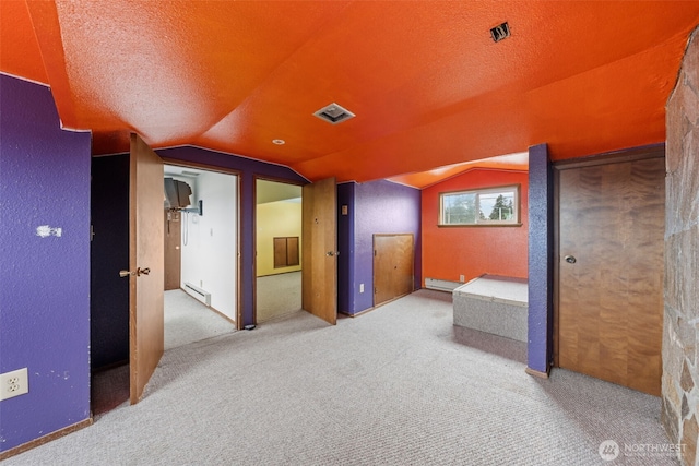 additional living space with a baseboard radiator, carpet floors, and vaulted ceiling