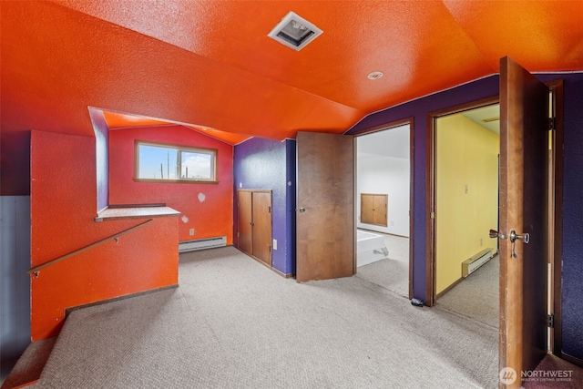 corridor featuring lofted ceiling, baseboard heating, and visible vents