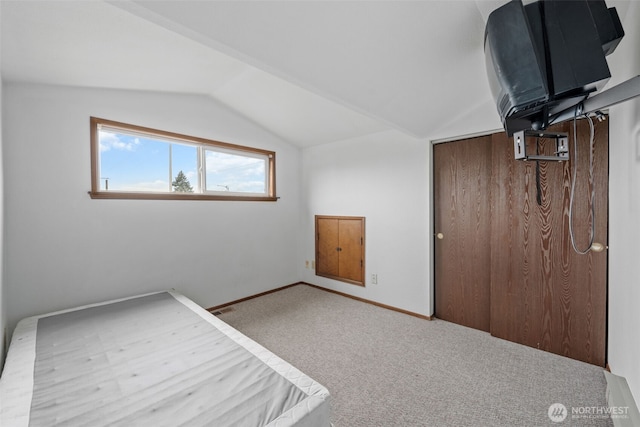 unfurnished bedroom featuring lofted ceiling, visible vents, carpet flooring, and baseboards