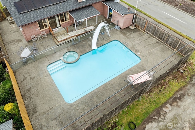 view of swimming pool with a water slide, a patio area, and a fenced backyard