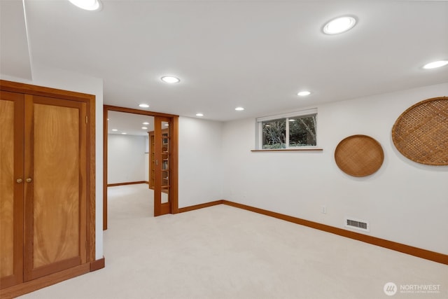 basement with light colored carpet, baseboards, visible vents, and recessed lighting