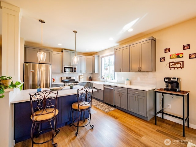806 Cody St SE, Rainier, WA 98576 - kitchen featuring stainless steel appliances, a breakfast bar area, a sink, a peninsula, and tasteful backsplash