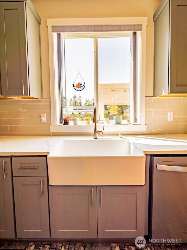 806 Cody St SE, Rainier, WA 98576 - kitchen featuring stainless steel dishwasher, decorative backsplash, a sink, and light countertops