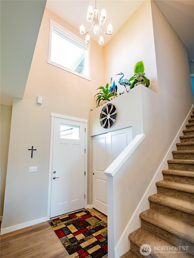 806 Cody St SE, Rainier, WA 98576 - entrance foyer with stairs, wood finished floors, a high ceiling, a chandelier, and baseboards