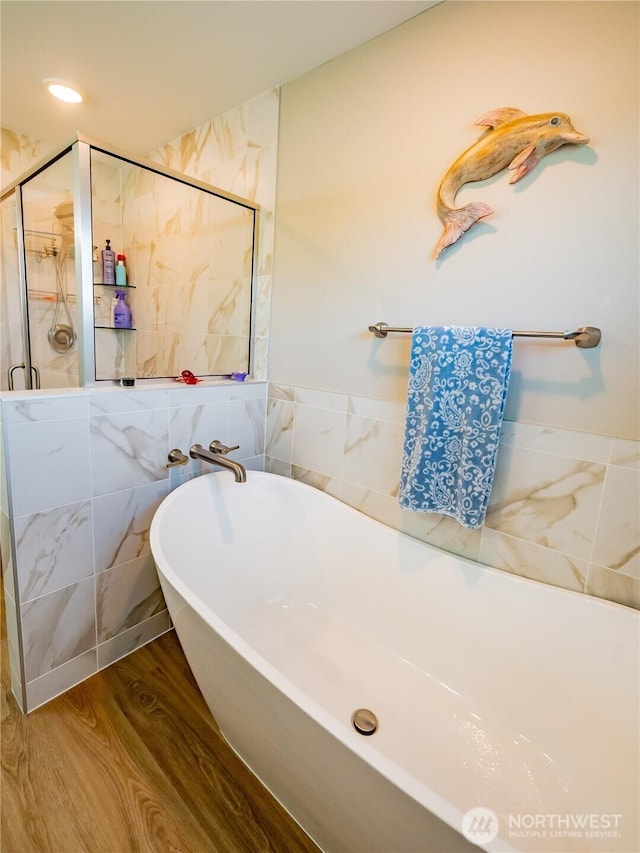 806 Cody St SE, Rainier, WA 98576 - full bathroom featuring tile walls, a stall shower, a freestanding tub, and wood finished floors