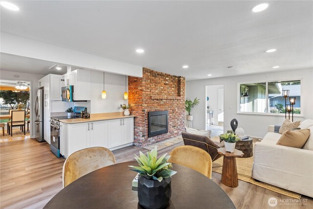 interior space with a fireplace, light wood-type flooring, and recessed lighting