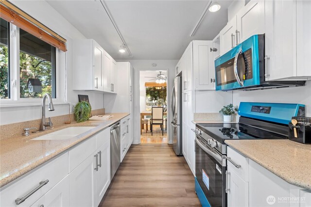 kitchen with white cabinetry, stainless steel appliances, and a sink