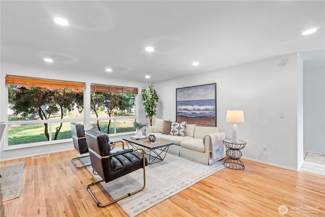 living area featuring wood finished floors, recessed lighting, visible vents, and baseboards