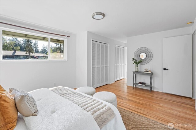 bedroom featuring wood finished floors and two closets